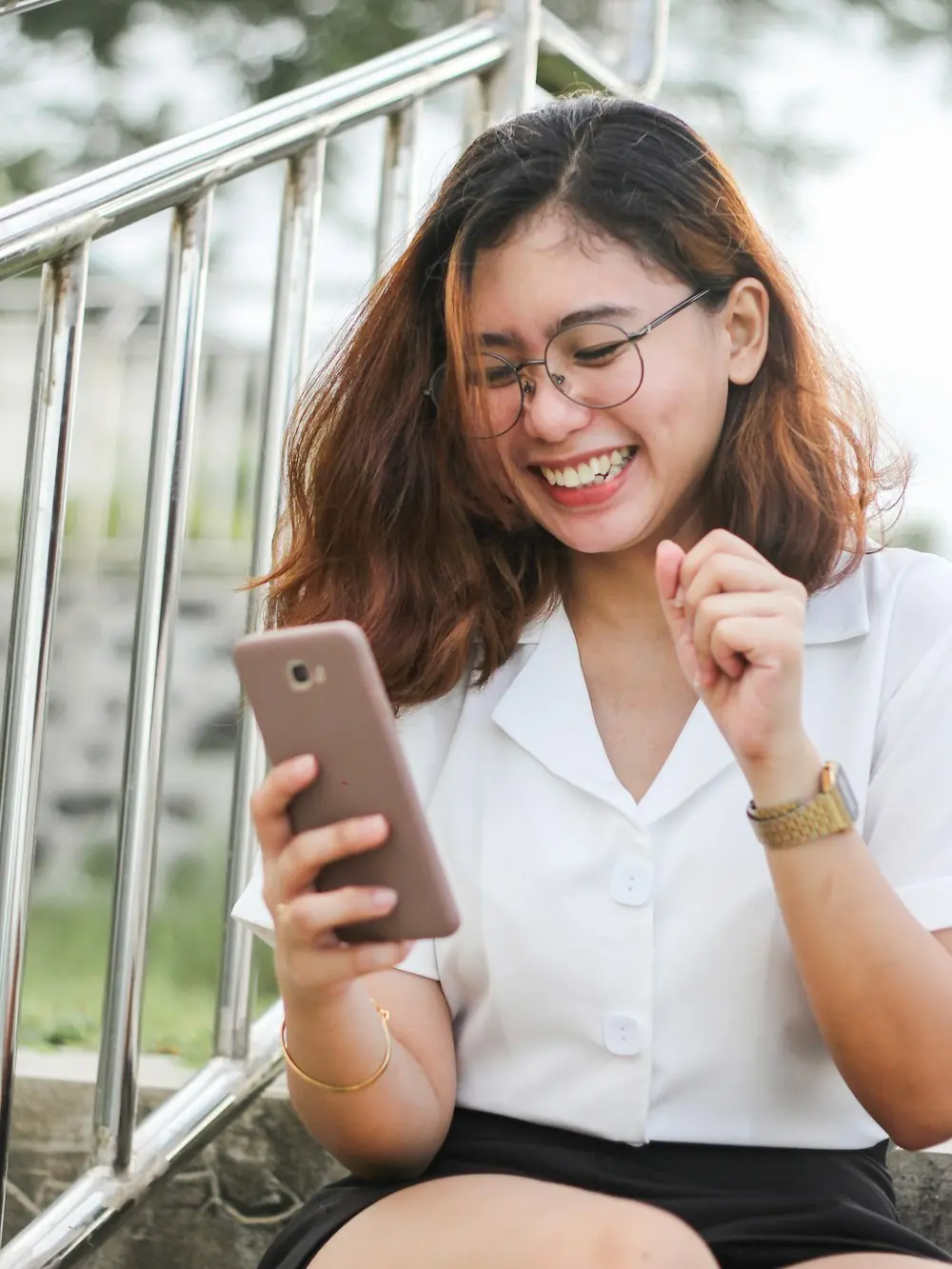Mulher sorrindo ao ler uma mensagem no celular